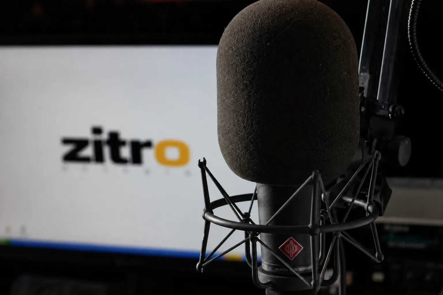 Micrófono Neumann en estudio profesional con el logotipo de ZITRO en la pantalla